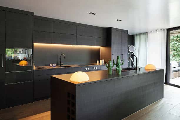 reforma intregral de cocina con isla central de estilo moderno y minimalista en tonos negros 